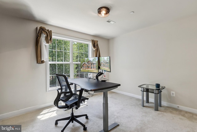 office area with baseboards, visible vents, and light carpet