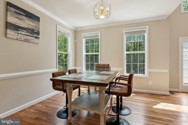 dining room featuring crown molding, baseboards, a notable chandelier, and wood finished floors
