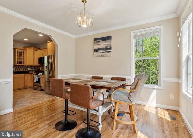dining space featuring a healthy amount of sunlight, light wood-style flooring, and visible vents
