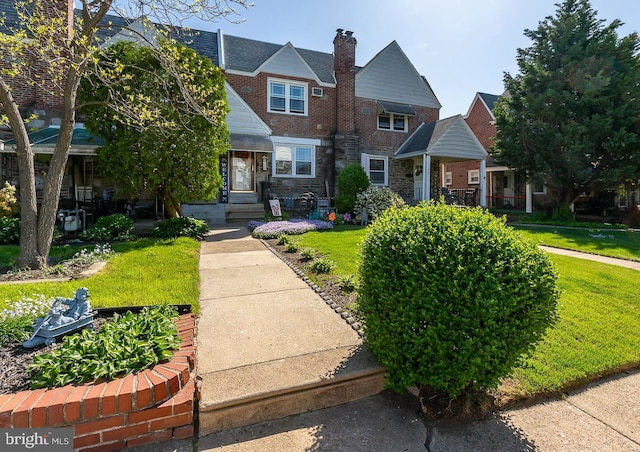 view of front of house featuring a front lawn and a chimney