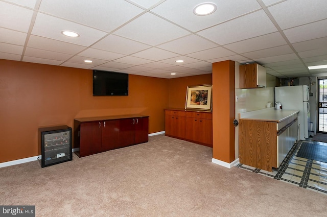 bar featuring carpet floors, baseboards, and a drop ceiling