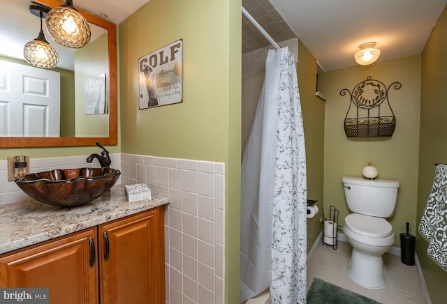 bathroom featuring a shower with curtain, tile walls, tile patterned floors, vanity, and toilet