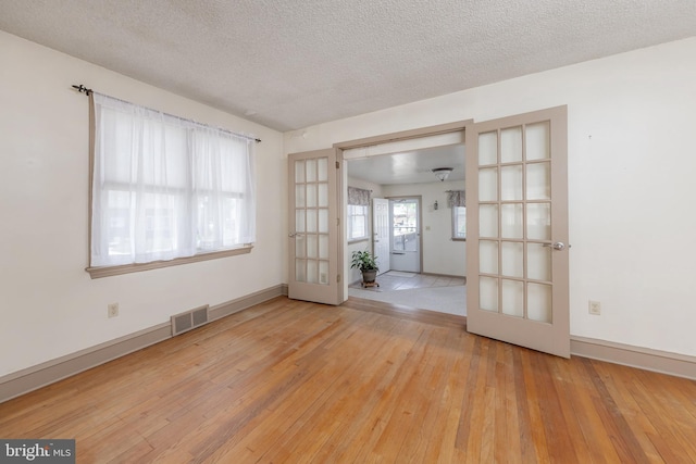161 E Ave, Woodstown, NJ 08098 - empty room featuring french doors, wood-type flooring, a textured ceiling, and baseboards