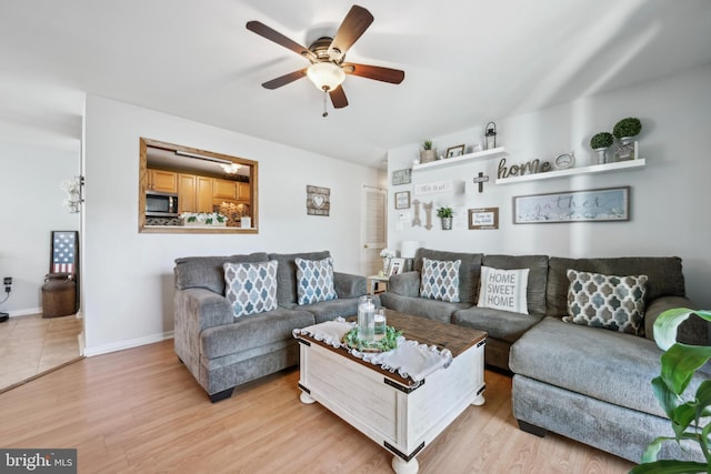 living room with baseboards, light wood finished floors, and ceiling fan