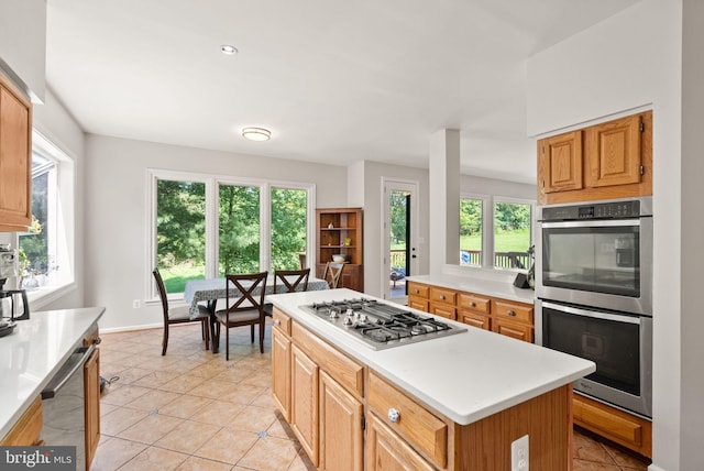 20665 Shoal Pl, Sterling, VA 20165 - kitchen with appliances with stainless steel finishes, light countertops, a center island, and light tile patterned flooring