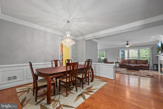 dining area with crown molding, visible vents, a wealth of natural light, and wood finished floors