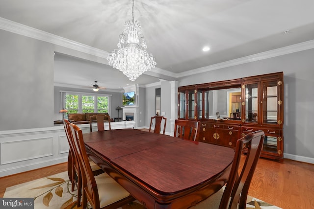 dining space with ornamental molding, a fireplace, and wood finished floors