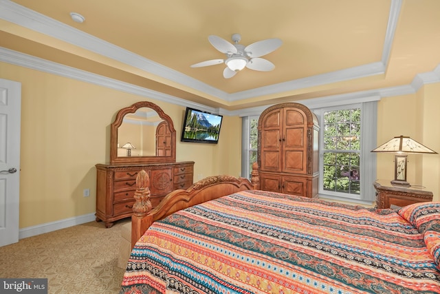 bedroom with crown molding, baseboards, ceiling fan, and a tray ceiling