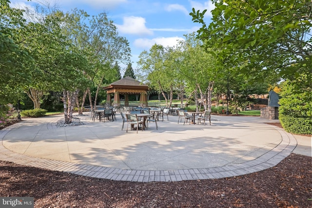 view of property's community featuring a gazebo, outdoor dining area, and a patio area
