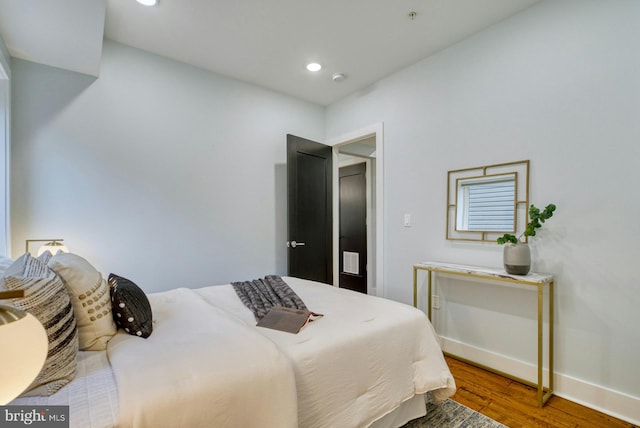 bedroom with wood finished floors, baseboards, and recessed lighting