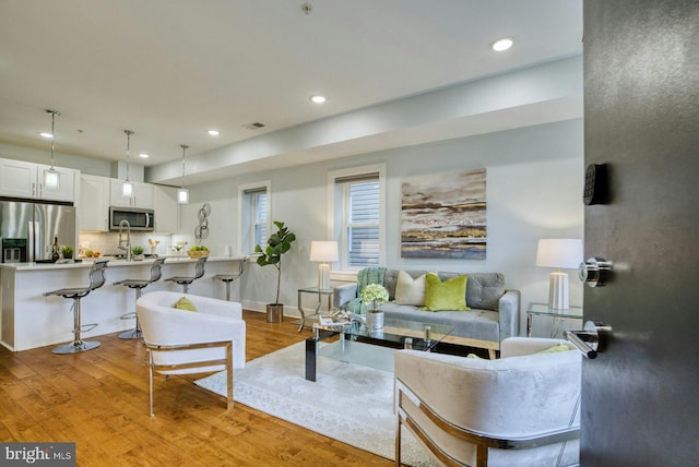 living room featuring light wood-style flooring and recessed lighting