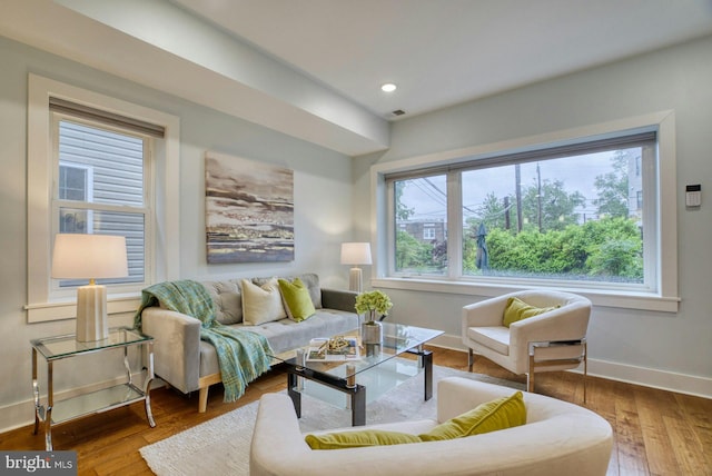 living area with baseboards, hardwood / wood-style flooring, and recessed lighting