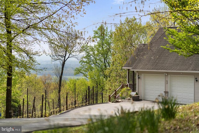 9831 Fox Rd, Frederick, MD 21702 - view of home's exterior featuring a shingled roof and a forest view
