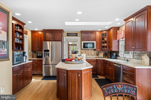 9831 Fox Rd, Frederick, MD 21702 - kitchen with light wood-style flooring, a skylight, a sink, and appliances with stainless steel finishes