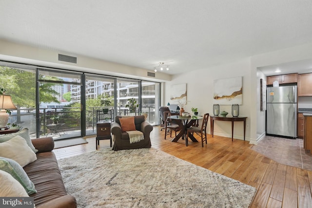 living room featuring visible vents, baseboards, and light wood-type flooring