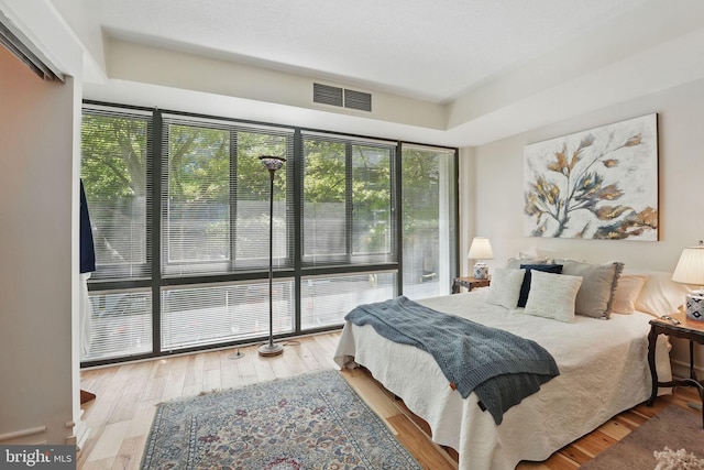 bedroom with visible vents and wood finished floors