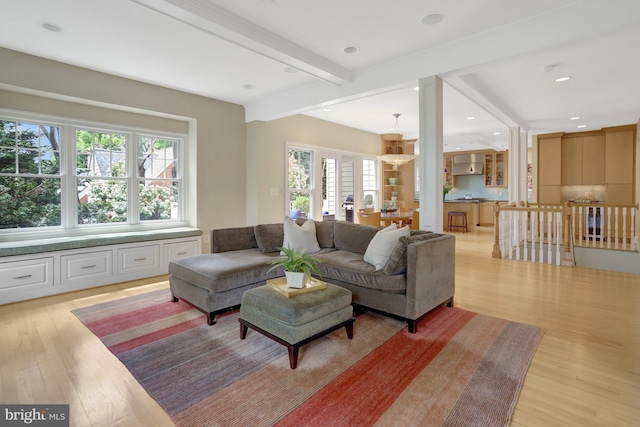 living room featuring light wood-style floors, recessed lighting, beam ceiling, and a wealth of natural light