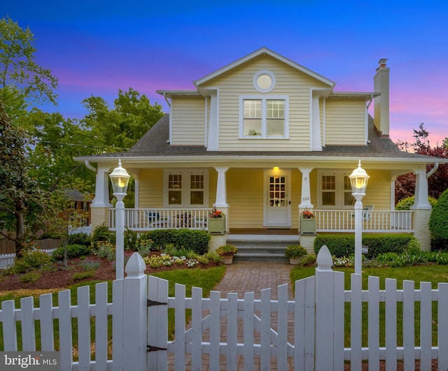 view of front of house featuring a fenced front yard, covered porch, and a chimney