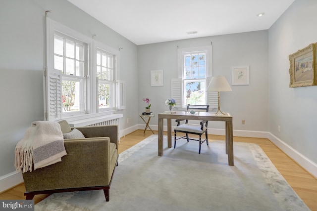 office space with baseboards, visible vents, and light wood-type flooring