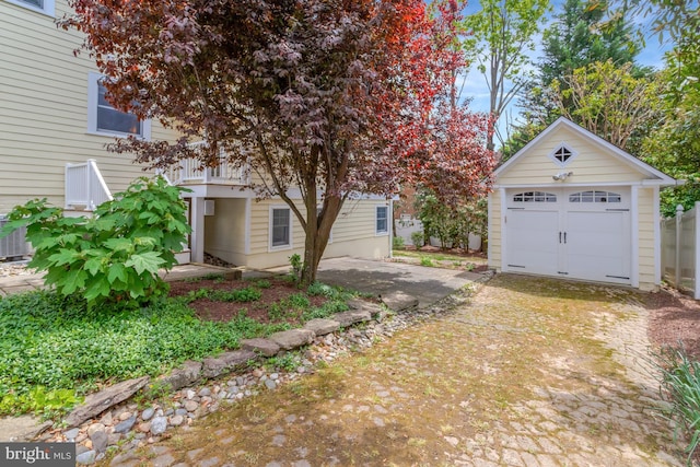 exterior space with a garage, an outbuilding, and driveway