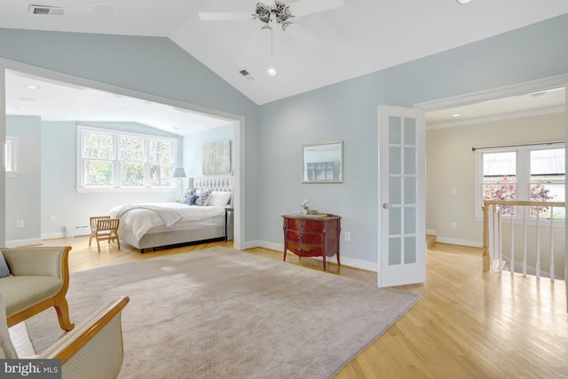 bedroom featuring a baseboard radiator, vaulted ceiling, light wood finished floors, and visible vents