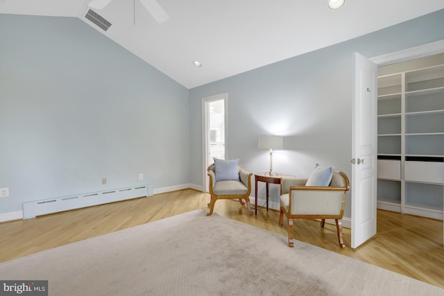 sitting room with visible vents, wood finished floors, ceiling fan, a baseboard heating unit, and vaulted ceiling