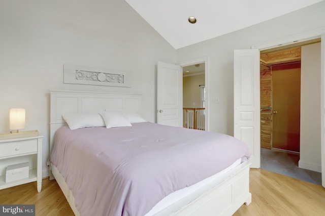 bedroom with baseboards, lofted ceiling, and light wood-type flooring