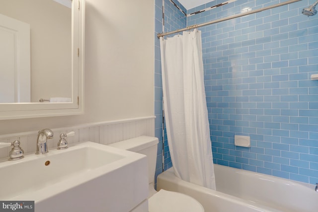 bathroom with toilet, a sink, and shower / bath combo