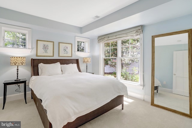 bedroom with baseboards, light carpet, and visible vents