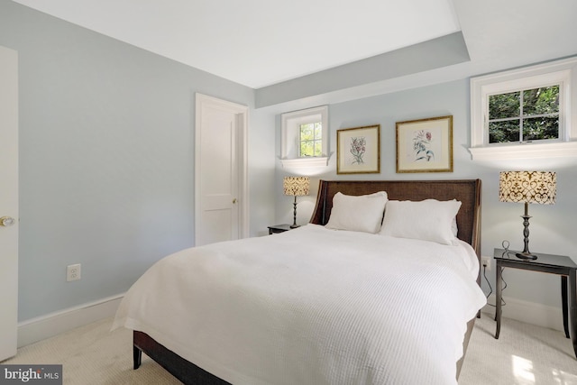 bedroom with baseboards and light carpet