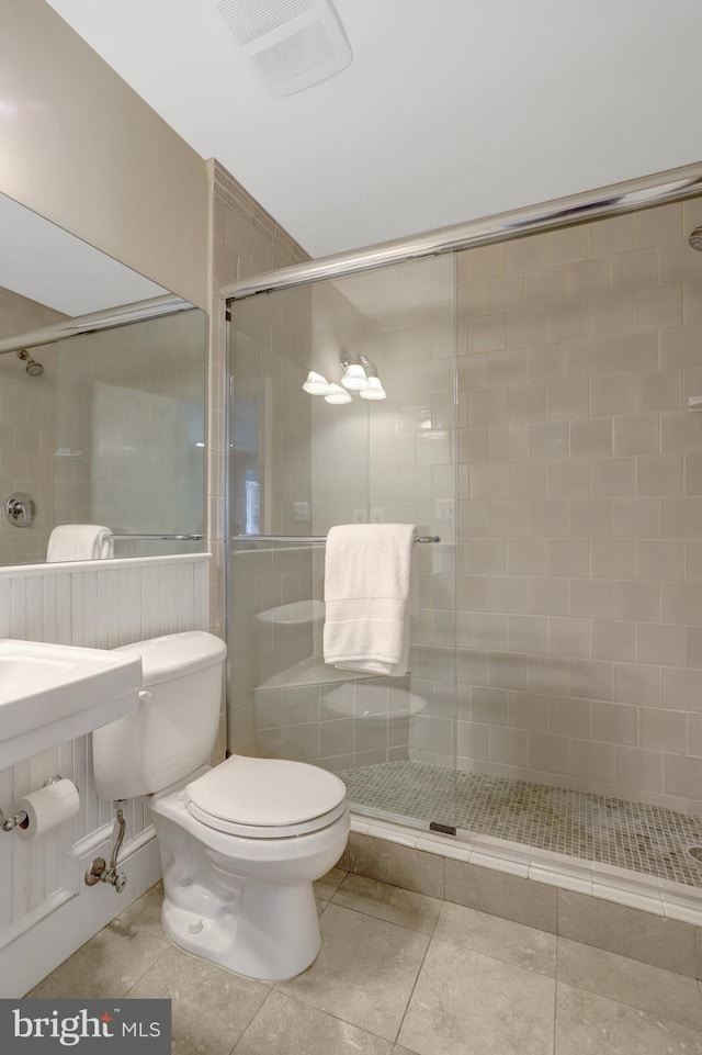 bathroom with visible vents, tile patterned flooring, a stall shower, and toilet