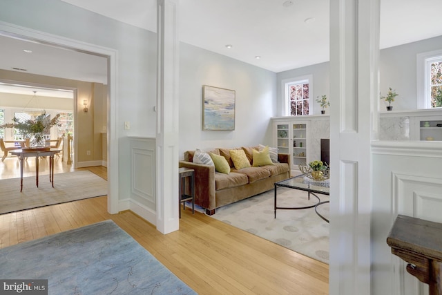 living area with wainscoting and hardwood / wood-style floors