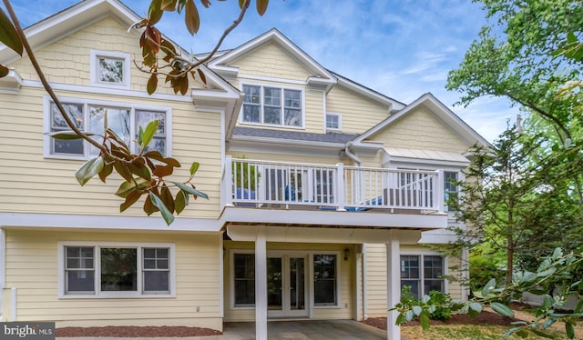 rear view of property featuring french doors, a patio, and a balcony