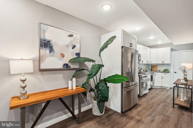 kitchen with recessed lighting, dark wood finished floors, appliances with stainless steel finishes, and white cabinets
