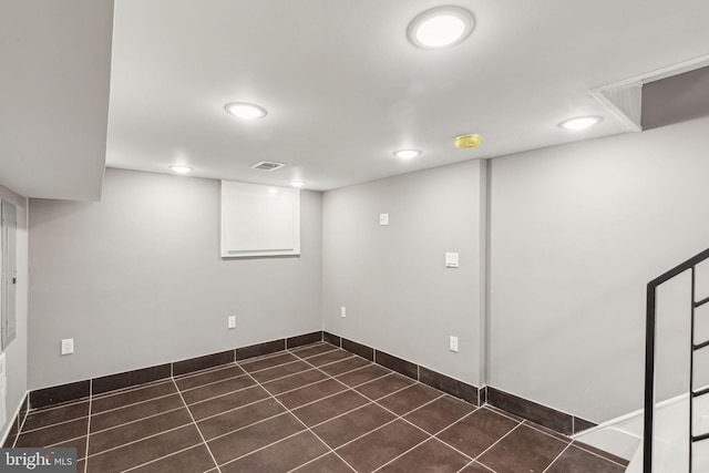 finished basement featuring dark tile patterned flooring, recessed lighting, baseboards, and visible vents