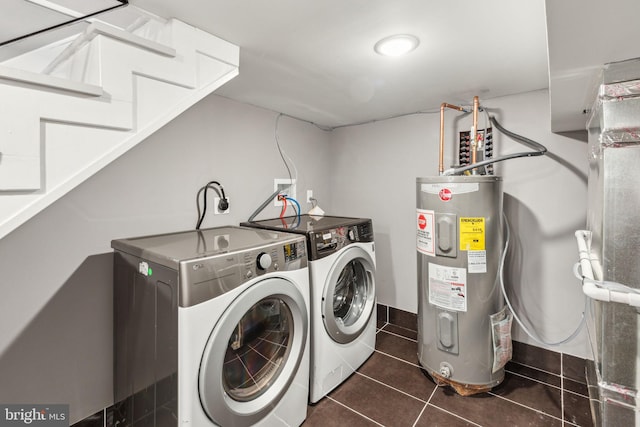 clothes washing area featuring washing machine and clothes dryer, laundry area, tile patterned floors, and electric water heater