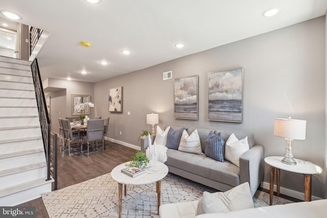 living area featuring visible vents, wood finished floors, baseboards, stairway, and recessed lighting
