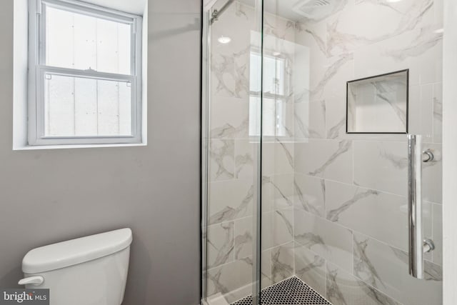 bathroom with a shower stall and toilet