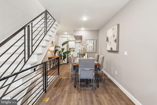 dining space featuring recessed lighting, baseboards, wood finished floors, and stairway