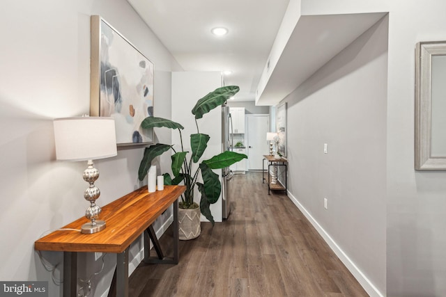 hallway with baseboards and wood finished floors