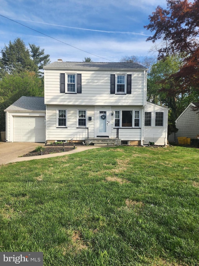 colonial house with entry steps, an attached garage, concrete driveway, and a front lawn