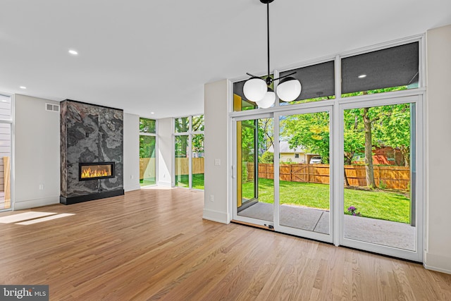 300 Ewing St, Princeton, NJ 08540 - unfurnished living room featuring wood finished floors, a high end fireplace, a wall of windows, baseboards, and recessed lighting