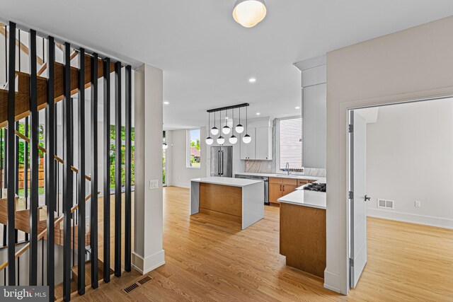 300 Ewing St, Princeton, NJ 08540 - kitchen featuring baseboards, light wood-type flooring, a kitchen island, light countertops, and a sink
