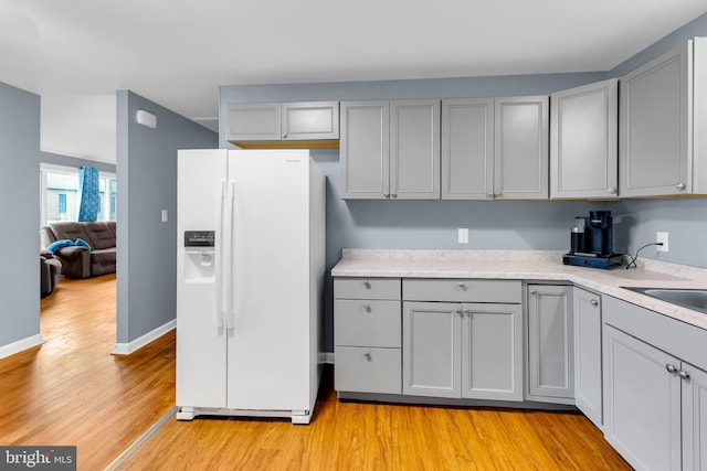 9 Central Ave, Pocomoke City, MD 21851 - kitchen featuring white refrigerator with ice dispenser, gray cabinetry, light wood-style flooring, and light countertops