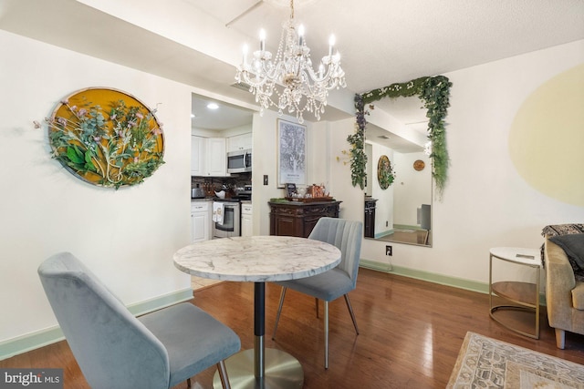 dining space featuring baseboards, wood finished floors, and a chandelier