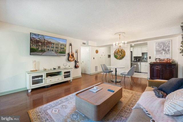 living area featuring baseboards, a chandelier, and wood finished floors