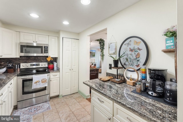 kitchen with dark stone counters, tasteful backsplash, stainless steel appliances, and white cabinets