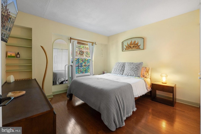 bedroom featuring baseboards and hardwood / wood-style floors