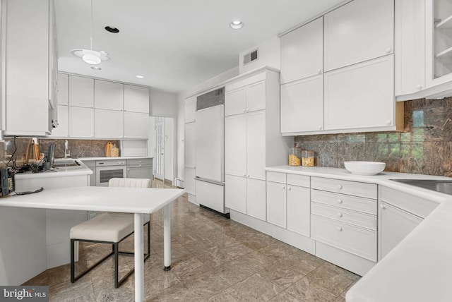 8300 Cedar Rd, Elkins Park, PA 19027 - kitchen featuring white cabinets, decorative backsplash, and built in fridge