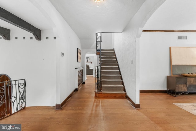 8300 Cedar Rd, Elkins Park, PA 19027 - stairway with arched walkways, hardwood / wood-style floors, baseboards, and visible vents